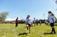 Kid practicing outdoors on grass, focusing on improving sports skills and enjoying the activity