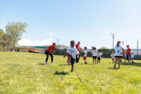 Kid practicing sports outdoors on grass, focused on improving skills