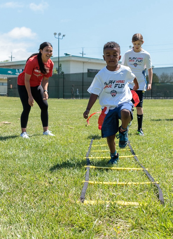 Children running and playing on the grass during a school field day, enjoying outdoor activities and games
